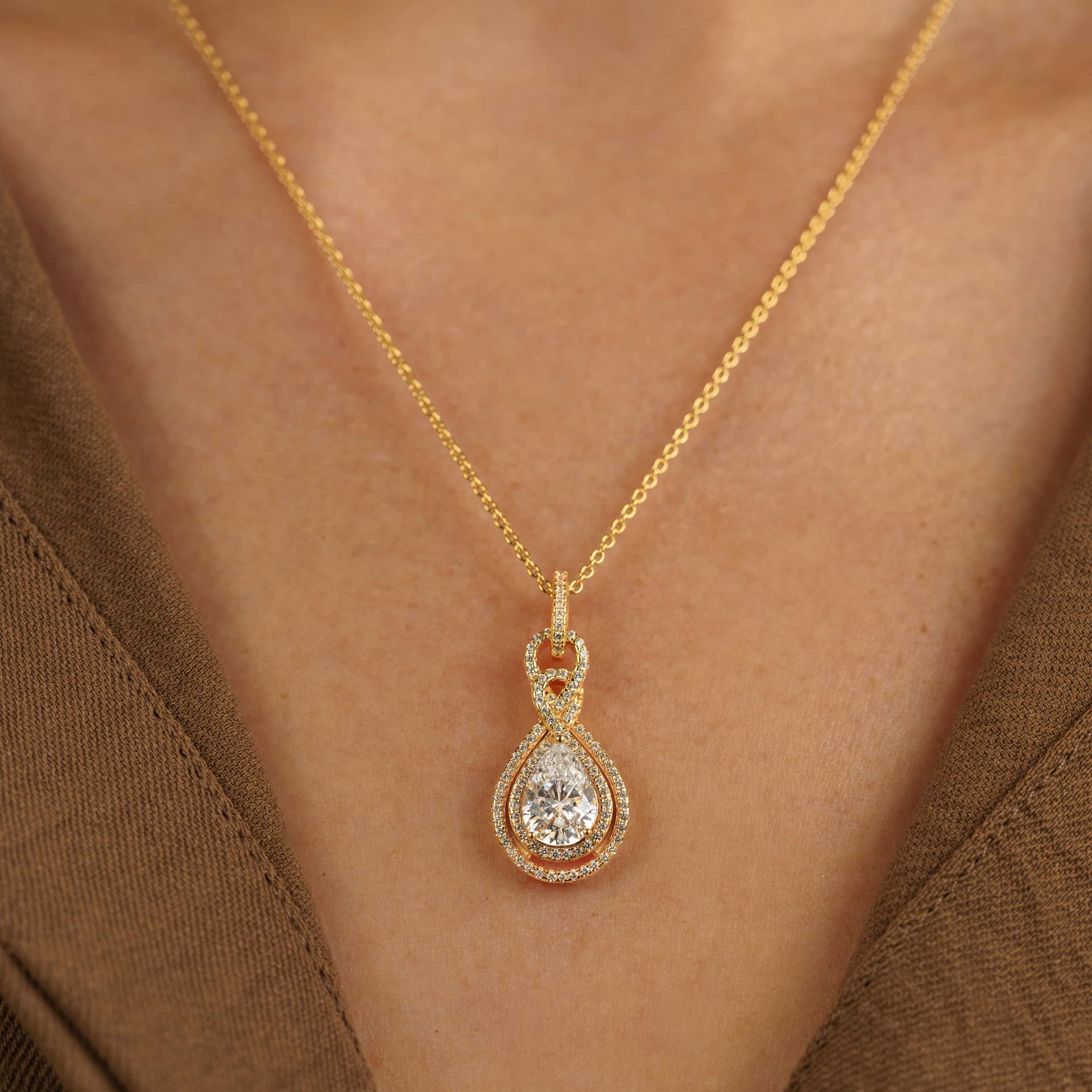 stunning gold pendant bridal necklace on model wearing a brown top