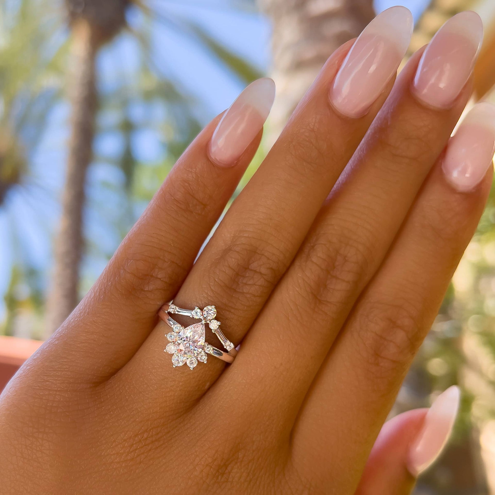 gorgeous silver vintage pear cut engagement ring on model with neutral pink nails