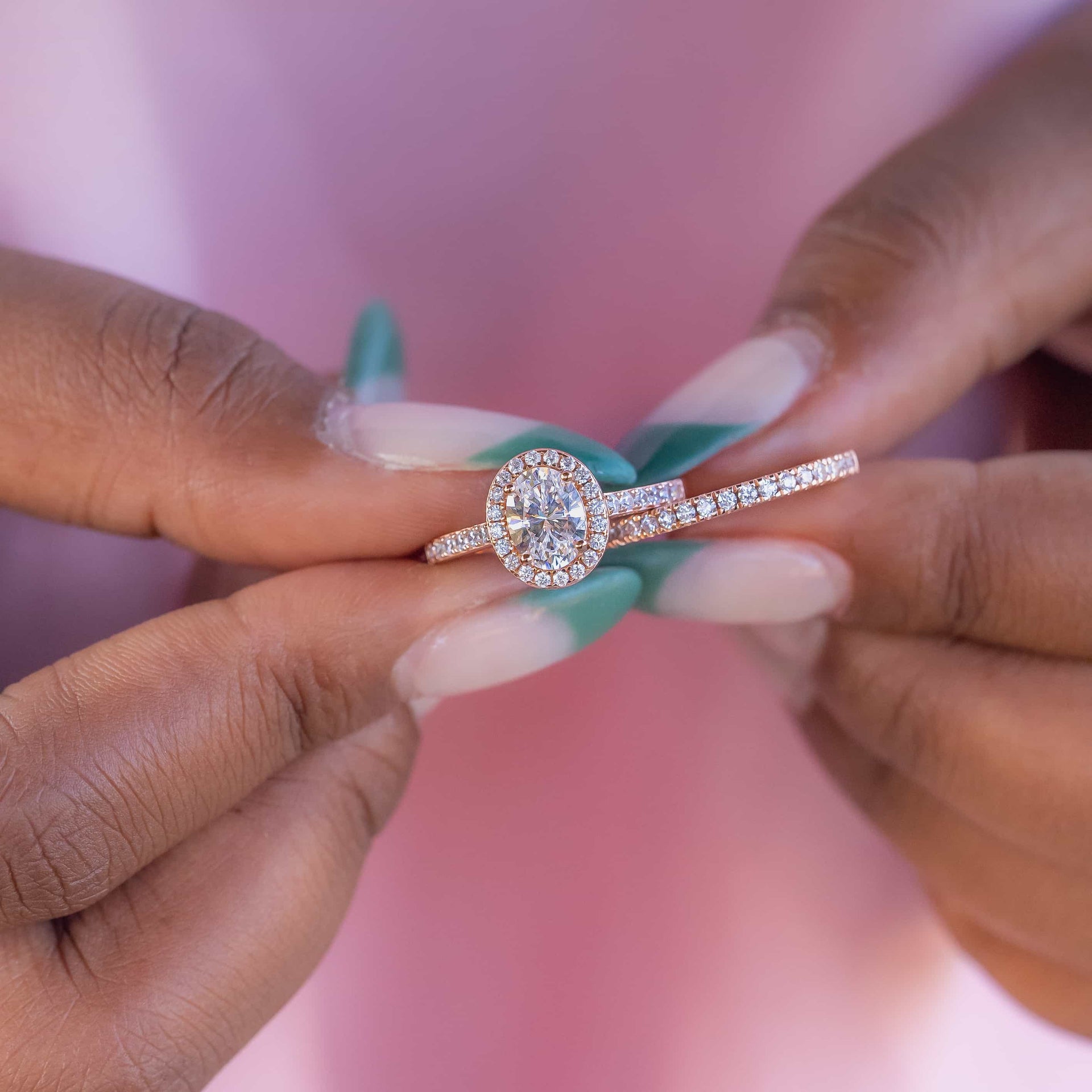 Female hand holding a vintage rose gold engagement ring and wedding band