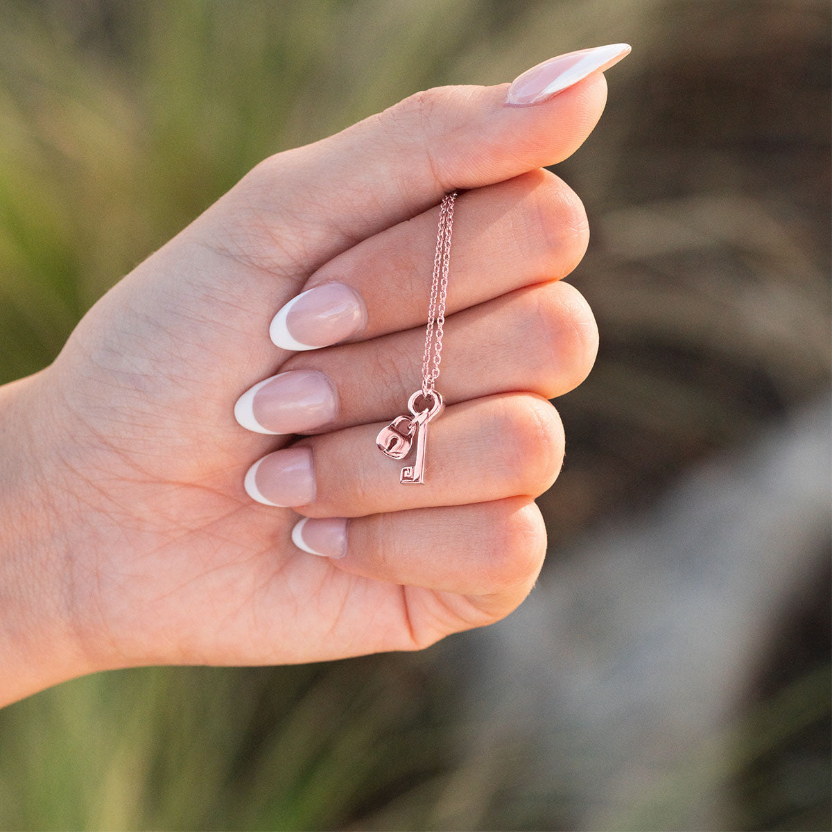 Model holding rose gold affinity necklace