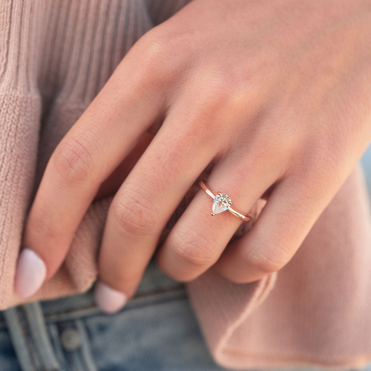 Woman wearing rose gold pear cut ring