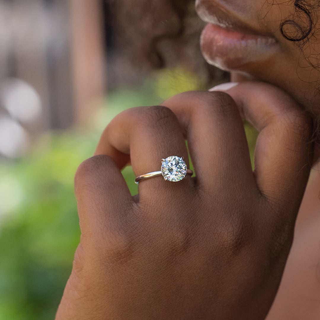 hand wearing round solitaire ring