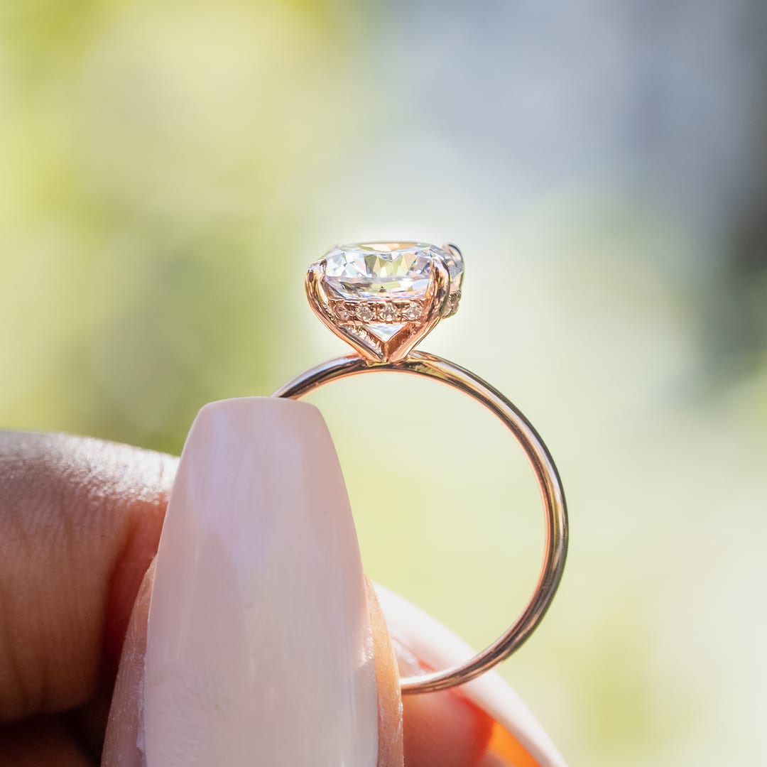 ladies fingers holding rose gold ring