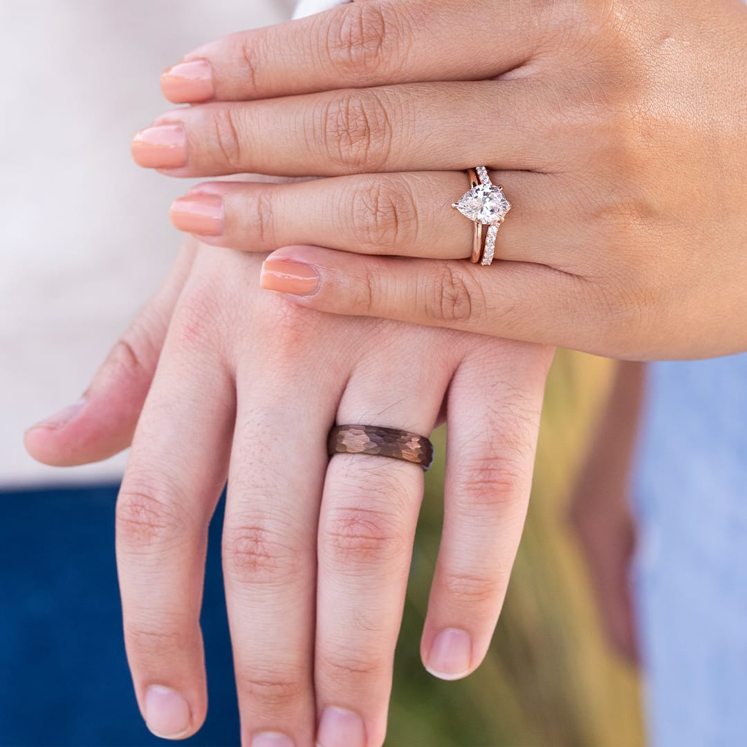 couple holding hands wearing wedding rings