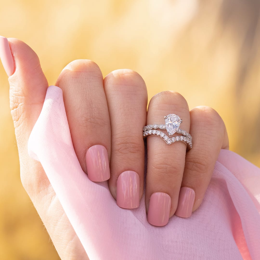 the scarlett vintage pear cut engagement ring stacked with wedding bands